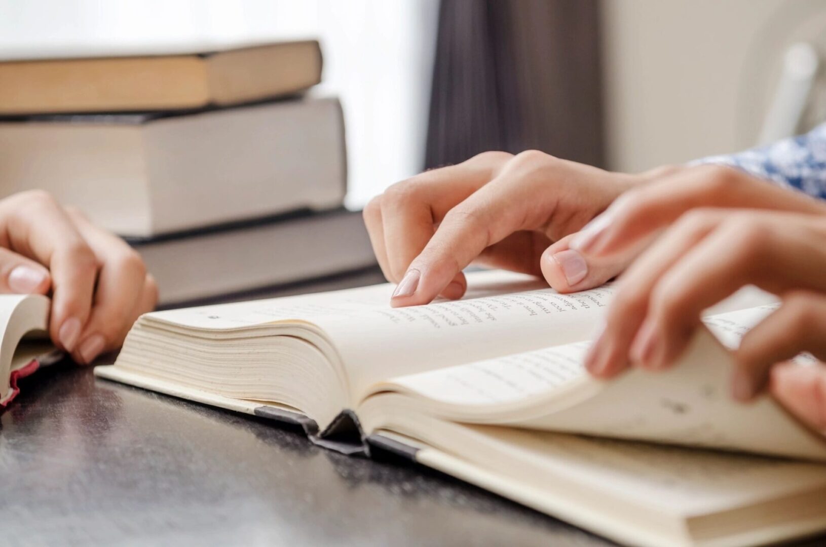 A person is reading a book on the table