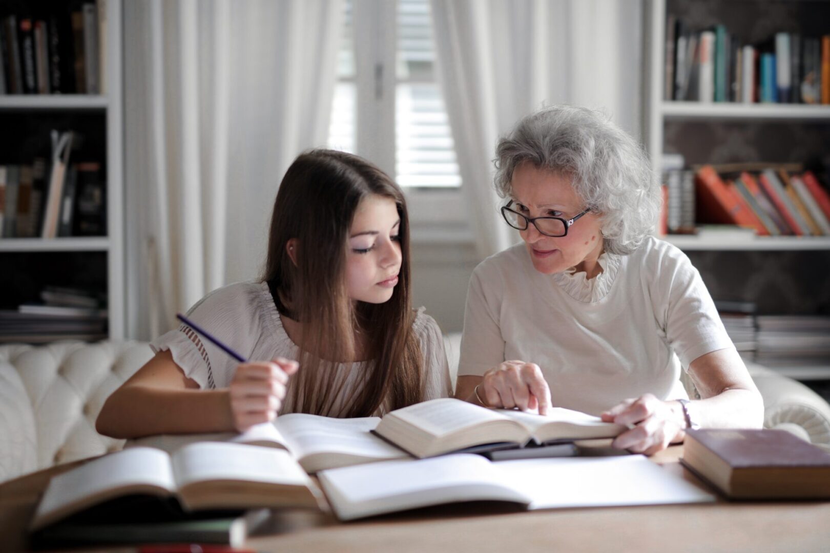 A woman and girl are studying at the table.